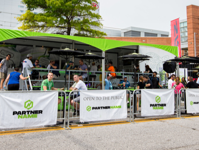 Covered outdoor seating area with sponsor signs covering the barriers.